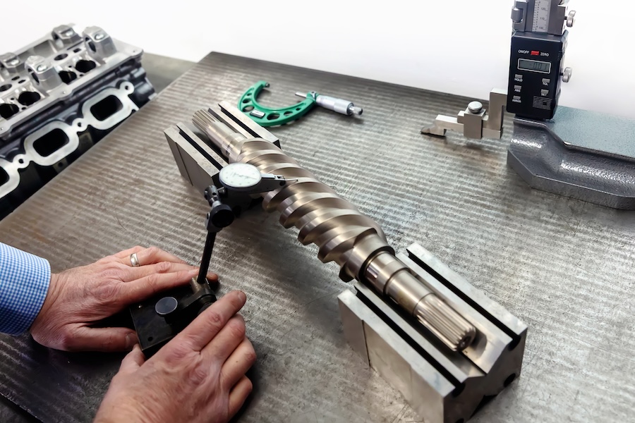 engineer hands measuring a machined shaft with dial gauge at PTL engineering